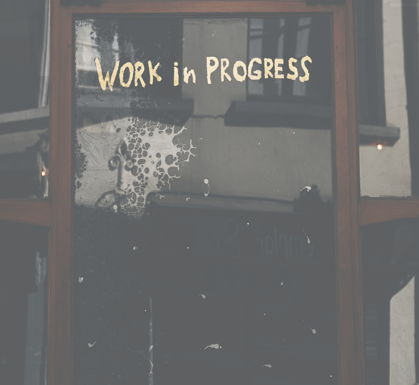 A store window with the words 'Work in progress' painted along the top